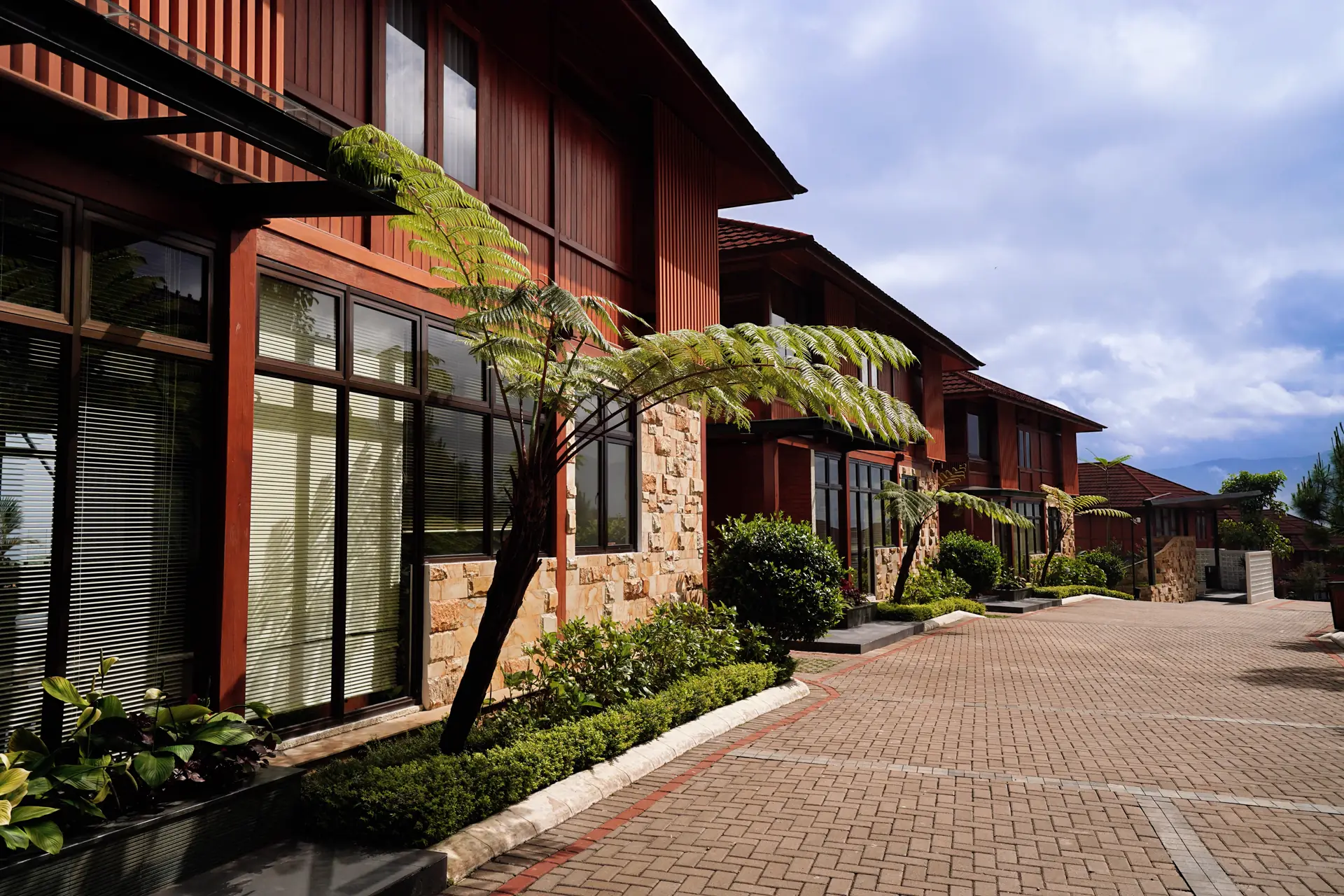 Row of timber villas along a garden path