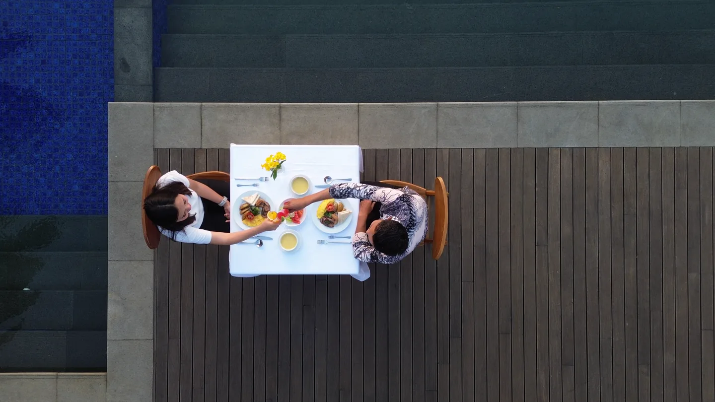 Guests dining by the pool, seen from above